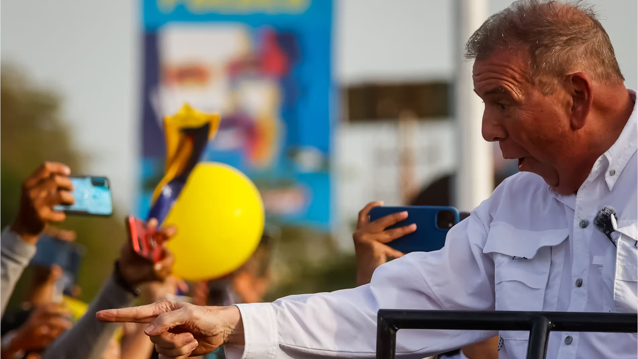 Эдмундо Гонсалес Уррутиа приветствует сторонников во время предвыборного мероприятия в Пуэрто-ла-Крус
